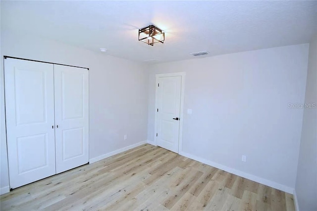 1 Fanshawe Ln, Palm Coast, FL 32137 - unfurnished bedroom with wood finished floors, baseboards, visible vents, and a closet