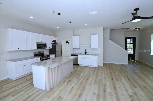 1 Fanshawe Ln, Palm Coast, FL 32137 - kitchen featuring a center island, a sink, appliances with stainless steel finishes, and light wood-style floors