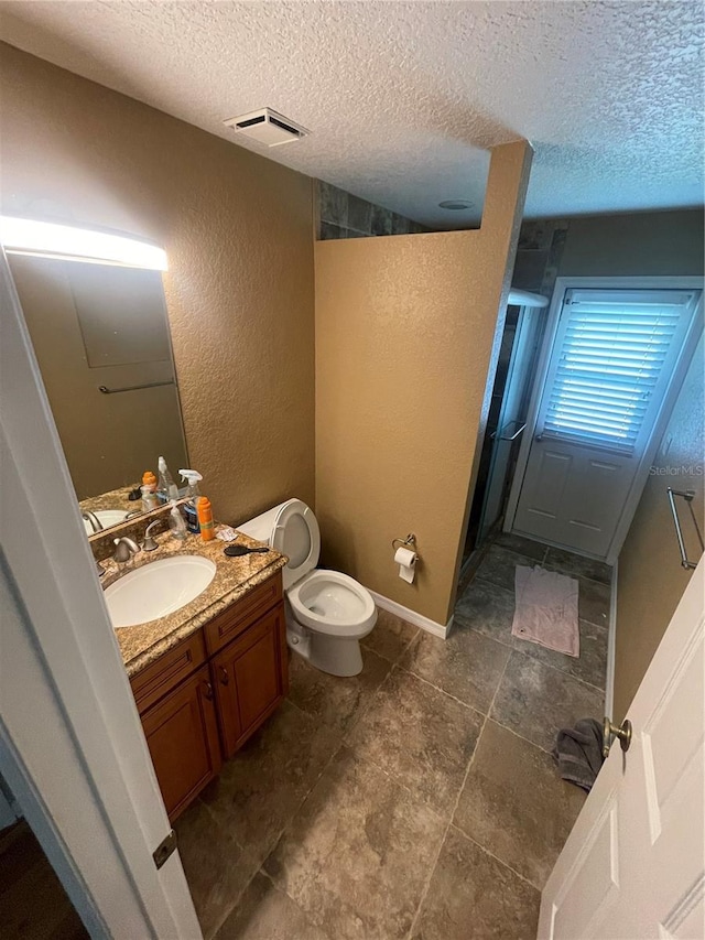 1501 Lambert Ave, Flagler Beach, FL 32136 - bathroom with a textured wall, a textured ceiling, vanity, a shower stall, and toilet