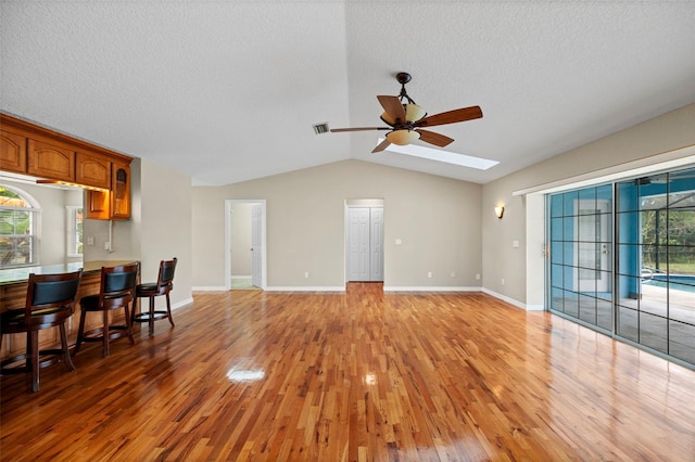 1501 Lambert Ave, Flagler Beach, FL 32136 - living room featuring light wood-type flooring, ceiling fan, plenty of natural light, vaulted ceiling, and a textured ceiling