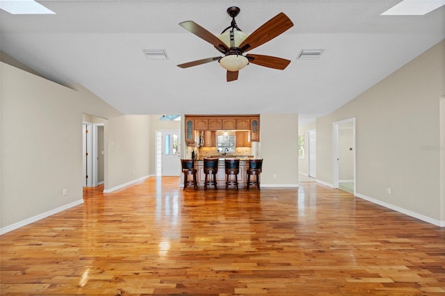 1501 Lambert Ave, Flagler Beach, FL 32136 - unfurnished living room with a skylight, vaulted ceiling, light wood finished floors, and a ceiling fan