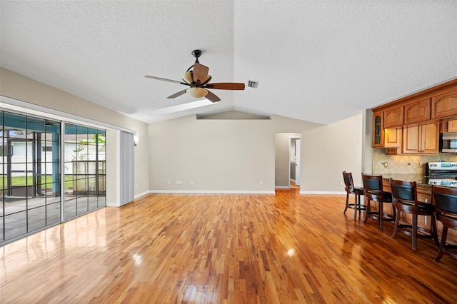 1501 Lambert Ave, Flagler Beach, FL 32136 - living room with ceiling fan, light wood-style floors, lofted ceiling, and a textured ceiling