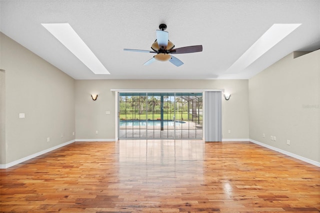 1501 Lambert Ave, Flagler Beach, FL 32136 - unfurnished room with a skylight, a ceiling fan, light wood-style floors, and lofted ceiling