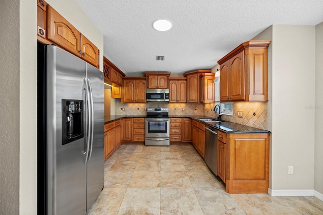 1501 Lambert Ave, Flagler Beach, FL 32136 - kitchen with appliances with stainless steel finishes, brown cabinetry, decorative backsplash, a textured ceiling, and dark stone counters