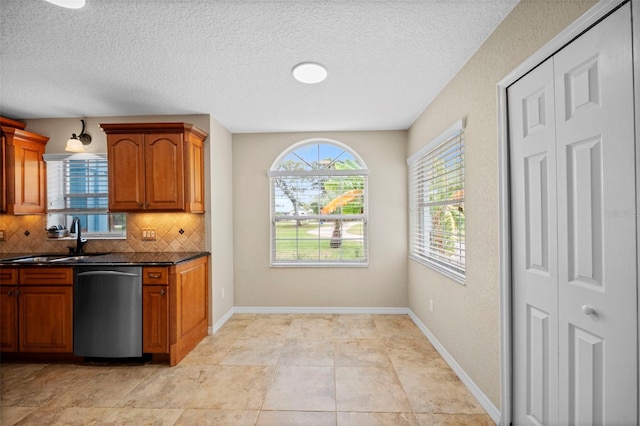 1501 Lambert Ave, Flagler Beach, FL 32136 - kitchen featuring stainless steel dishwasher, tasteful backsplash, brown cabinetry, and a textured ceiling