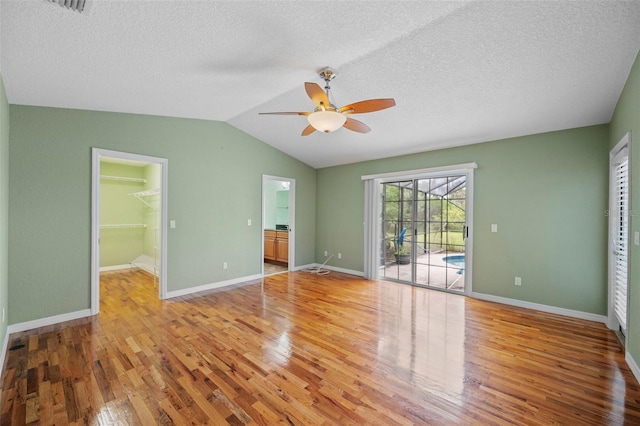 1501 Lambert Ave, Flagler Beach, FL 32136 - unfurnished bedroom with light wood-style flooring, access to exterior, lofted ceiling, a spacious closet, and a textured ceiling
