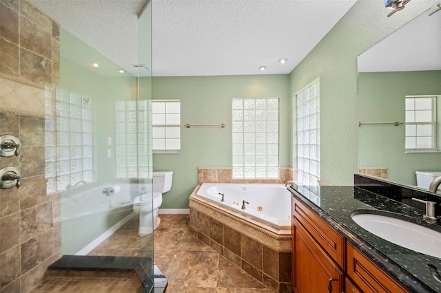 1501 Lambert Ave, Flagler Beach, FL 32136 - bathroom with a jetted tub, healthy amount of natural light, vanity, a textured ceiling, and tiled shower
