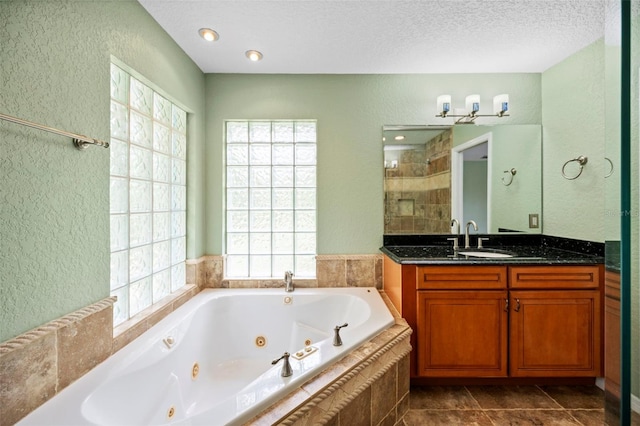 1501 Lambert Ave, Flagler Beach, FL 32136 - bathroom featuring a textured wall, vanity, a tub with jets, plenty of natural light, and a textured ceiling