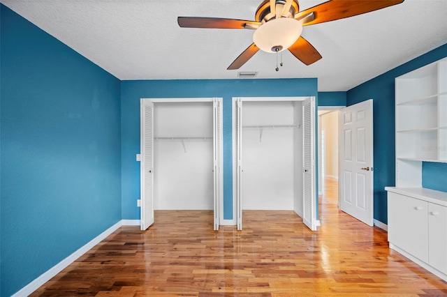 1501 Lambert Ave, Flagler Beach, FL 32136 - unfurnished bedroom featuring multiple closets, light wood finished floors, and a ceiling fan