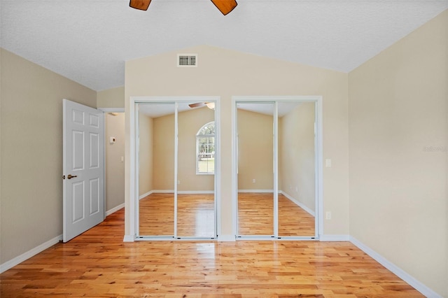 1501 Lambert Ave, Flagler Beach, FL 32136 - unfurnished bedroom featuring vaulted ceiling, two closets, light wood-style flooring, and ceiling fan
