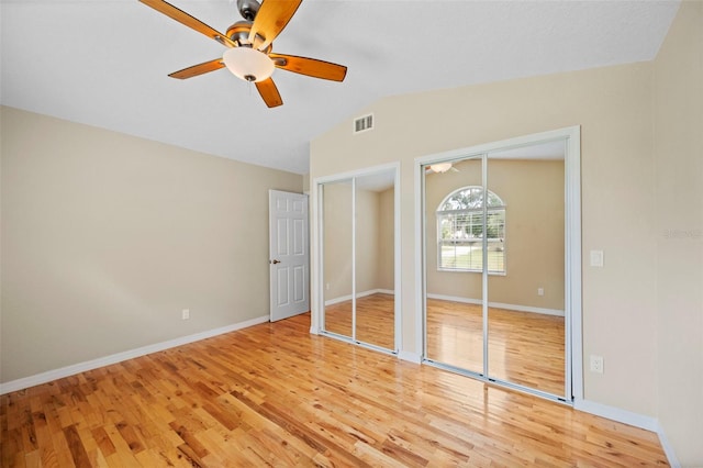 1501 Lambert Ave, Flagler Beach, FL 32136 - unfurnished bedroom featuring two closets, lofted ceiling, light wood finished floors, and a ceiling fan