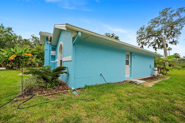 1501 Lambert Ave, Flagler Beach, FL 32136 - view of side of home with stucco siding and a lawn