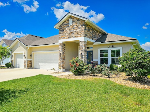 view of front of house featuring stone siding, stucco siding, a front yard, a garage, and driveway