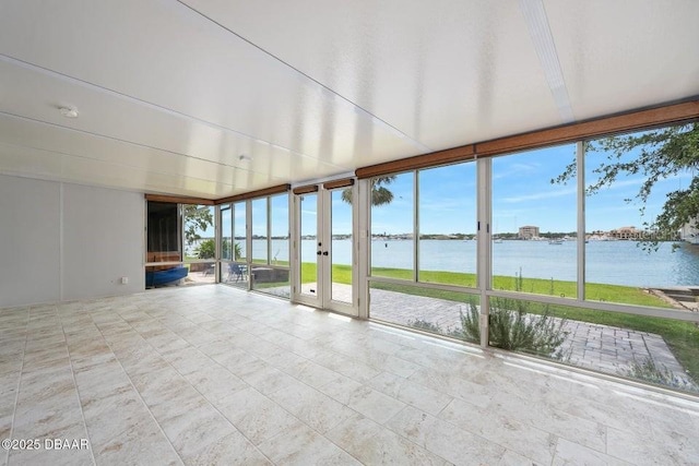 unfurnished sunroom featuring a water view, tile patterned flooring, french doors, and expansive windows