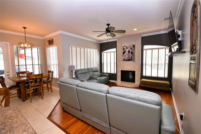 5 Baltimore Ln, Palm Coast, FL 32137 - living room with a premium fireplace, a wealth of natural light, visible vents, baseboards, and ceiling fan with notable chandelier
