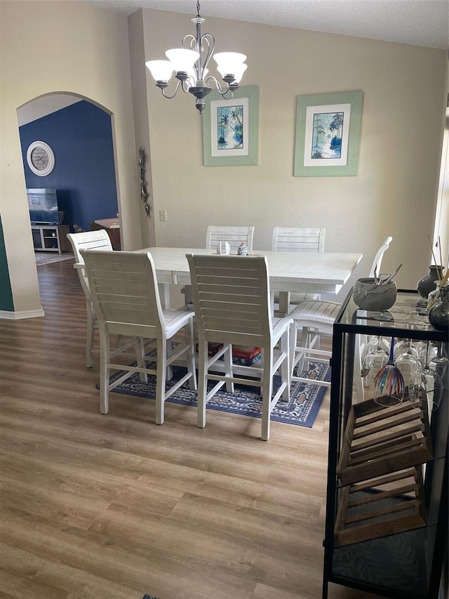 161 Bayside Dr, Palm Coast, FL 32137 - dining space with light wood-style floors, arched walkways, a chandelier, and baseboards