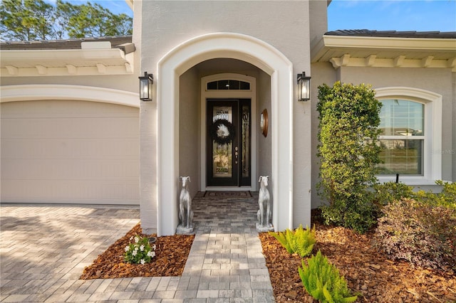 628 Mahogany Run, Palm Coast, FL 32137 - view of exterior entry featuring stucco siding, driveway, and an attached garage
