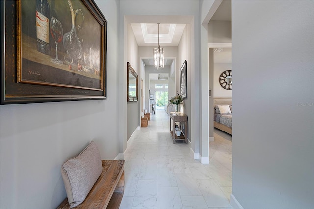 628 Mahogany Run, Palm Coast, FL 32137 - hall with a raised ceiling, a notable chandelier, marble finish floor, and baseboards