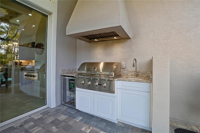 628 Mahogany Run, Palm Coast, FL 32137 - bar with a sink, a textured wall, premium range hood, an inviting chandelier, and wine cooler