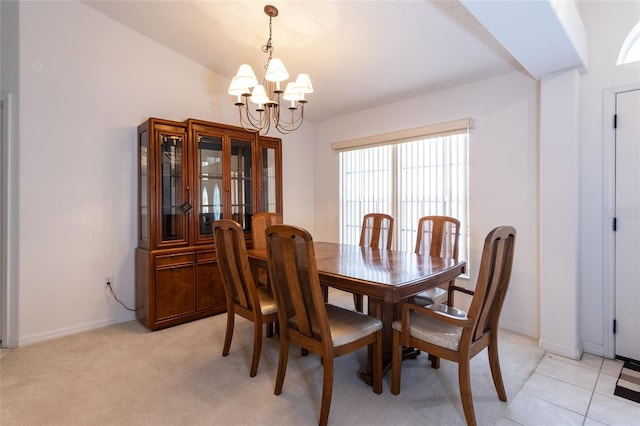 dining space with a chandelier, baseboards, lofted ceiling, and light colored carpet