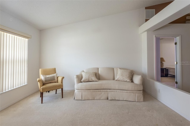 sitting room with visible vents, carpet floors, and baseboards