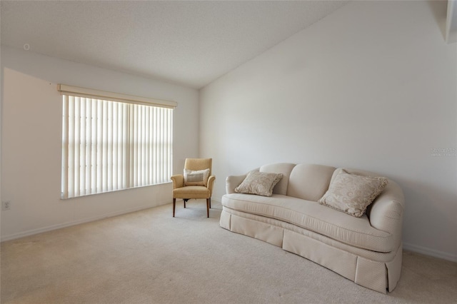 sitting room featuring carpet, vaulted ceiling, and baseboards
