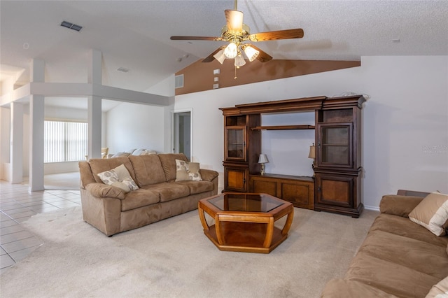 living room featuring light tile patterned floors, ceiling fan, vaulted ceiling, and visible vents