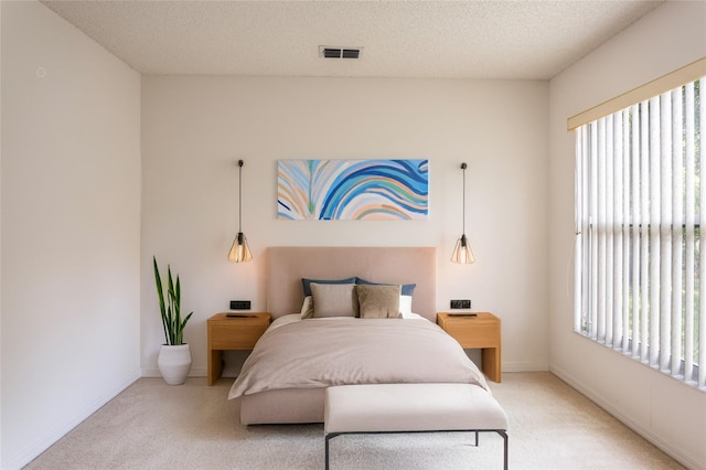 bedroom with baseboards, visible vents, a textured ceiling, and carpet