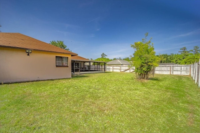 view of yard featuring a sunroom and a fenced backyard