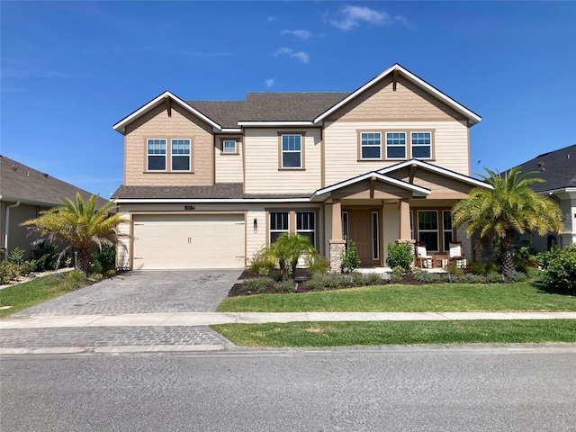 382 Aquamarine Way, Daytona Beach, FL 32124 - view of front of home with covered porch, decorative driveway, roof with shingles, a front yard, and an attached garage