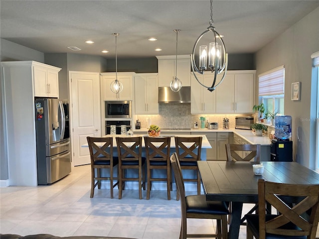 382 Aquamarine Way, Daytona Beach, FL 32124 - kitchen featuring white cabinetry, tasteful backsplash, stainless steel appliances, an inviting chandelier, and exhaust hood