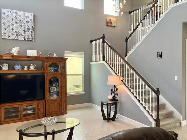 382 Aquamarine Way, Daytona Beach, FL 32124 - living room featuring stairs, light tile patterned floors, baseboards, a notable chandelier, and a high ceiling
