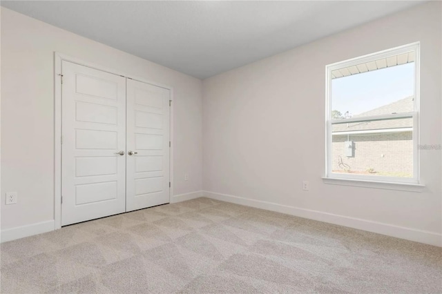 21 Uniondale Pl, Palm Coast, FL 32164 - unfurnished bedroom with a closet, baseboards, and light carpet