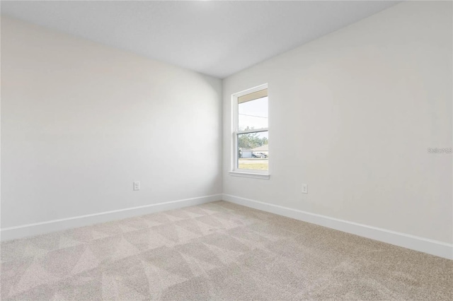 21 Uniondale Pl, Palm Coast, FL 32164 - spare room featuring baseboards and light carpet