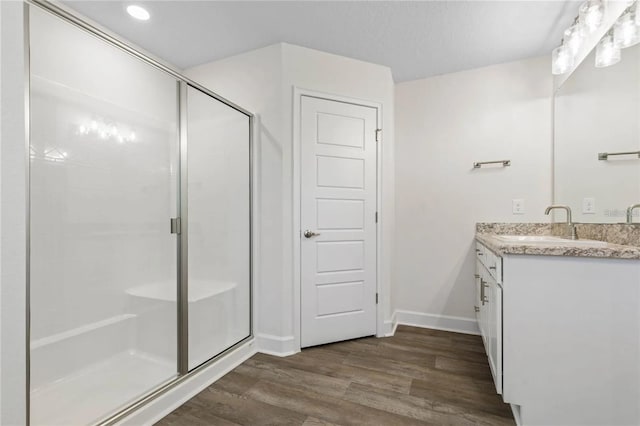 21 Uniondale Pl, Palm Coast, FL 32164 - bathroom with a stall shower, baseboards, wood finished floors, and vanity