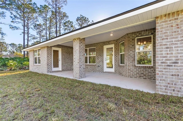 21 Uniondale Pl, Palm Coast, FL 32164 - rear view of property featuring a patio area, a yard, and brick siding