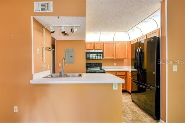 27 Catalonia Ct Unit A, Saint Augustine, FL 32086 - kitchen featuring visible vents, a peninsula, light countertops, a sink, and black appliances