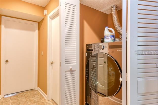 27 Catalonia Ct Unit A, Saint Augustine, FL 32086 - laundry area featuring laundry area, a textured ceiling, washer / dryer, and baseboards