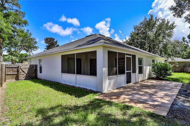 rear view of property with a lawn, a fenced backyard, a patio area, and a sunroom
