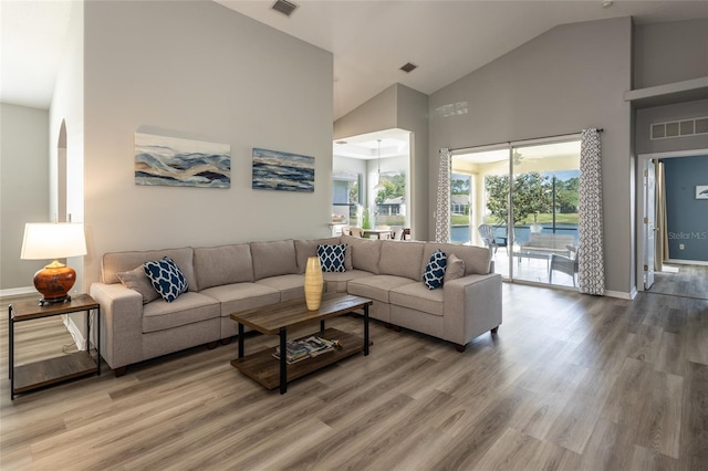 125 Raintree Cir, Palm Coast, FL 32164 - living room with light wood-type flooring, baseboards, visible vents, and high vaulted ceiling