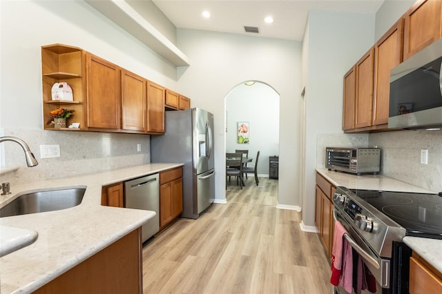 125 Raintree Cir, Palm Coast, FL 32164 - kitchen featuring a sink, stainless steel appliances, open shelves, visible vents, and arched walkways
