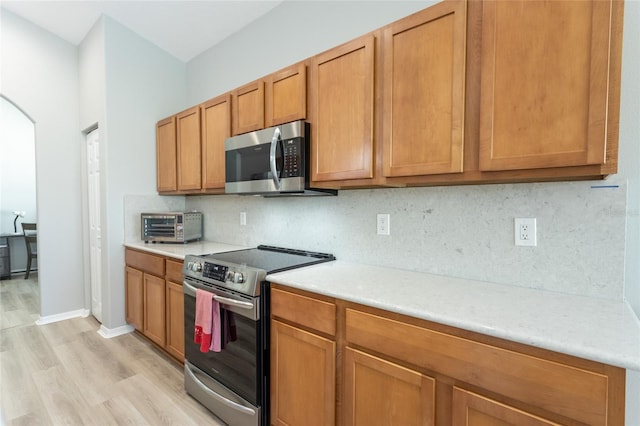 125 Raintree Cir, Palm Coast, FL 32164 - kitchen with backsplash, light countertops, appliances with stainless steel finishes, and light wood-style floors