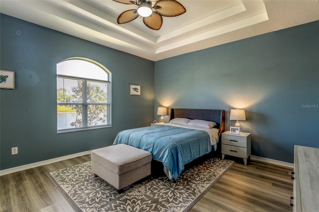 125 Raintree Cir, Palm Coast, FL 32164 - bedroom featuring baseboards, a tray ceiling, and wood finished floors