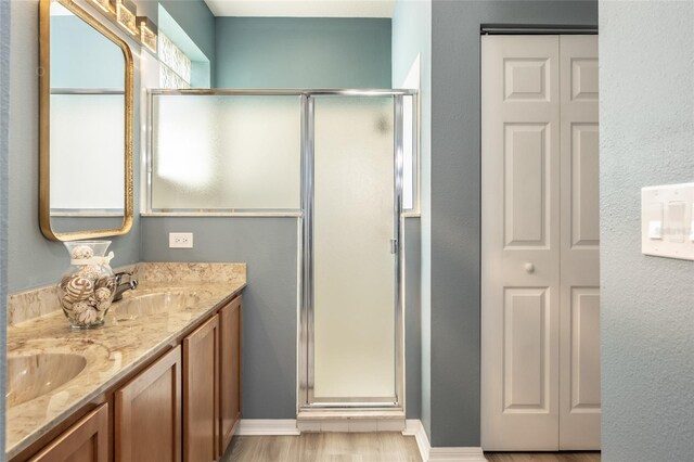 125 Raintree Cir, Palm Coast, FL 32164 - bathroom with a stall shower, double vanity, a sink, and wood finished floors