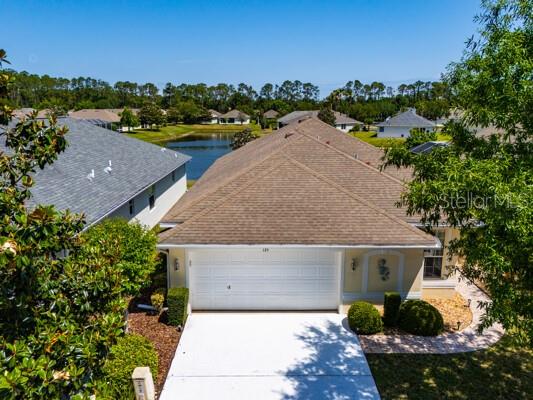 125 Raintree Cir, Palm Coast, FL 32164 - exterior space with a water view, driveway, roof with shingles, and an attached garage