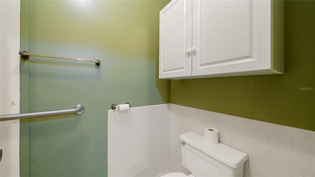 689 16th St, Saint Augustine, FL 32080 - bathroom featuring toilet, tile walls, and wainscoting