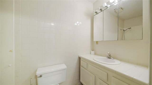 689 16th St, Saint Augustine, FL 32080 - bathroom with toilet, vanity, tasteful backsplash, and tile walls