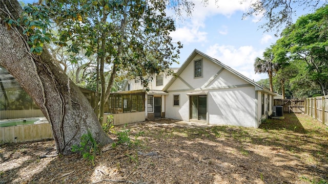 689 16th St, Saint Augustine, FL 32080 - back of property featuring a sunroom, stucco siding, a fenced backyard, and central air condition unit