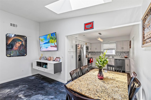 13 Belleaire Dr, Palm Coast, FL 32137 - dining room with a skylight, baseboards, and visible vents