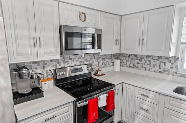 13 Belleaire Dr, Palm Coast, FL 32137 - kitchen featuring light countertops, white cabinets, and stainless steel appliances